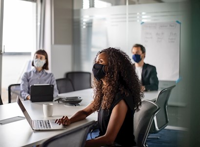 People in office meeting with masks