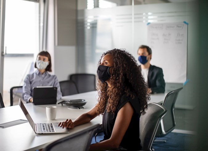 People in office meeting with masks