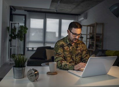Man in military uniform on computer.