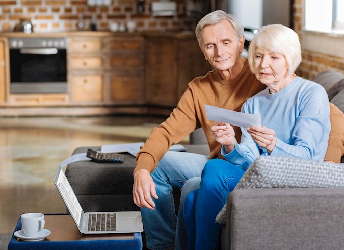 Older couple reading report on couch