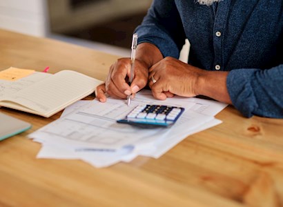 Close up of hands near a calculator